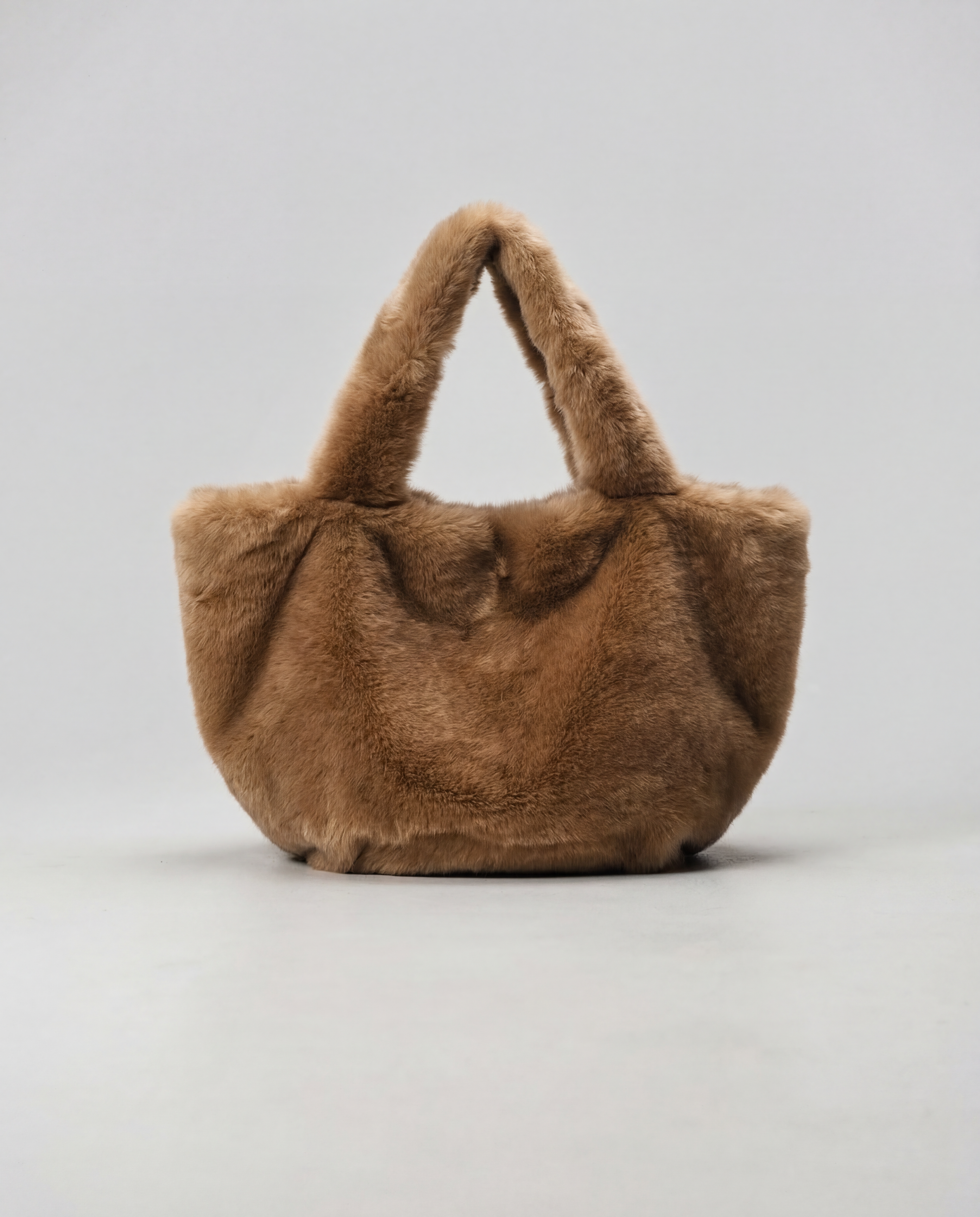Sac en fausse fourrure vegan brun miel aux reflets ambrés, texture douce effet velours, silhouette souple élégante, fabrication artisanale à Paris. Maison Quivernay. 
