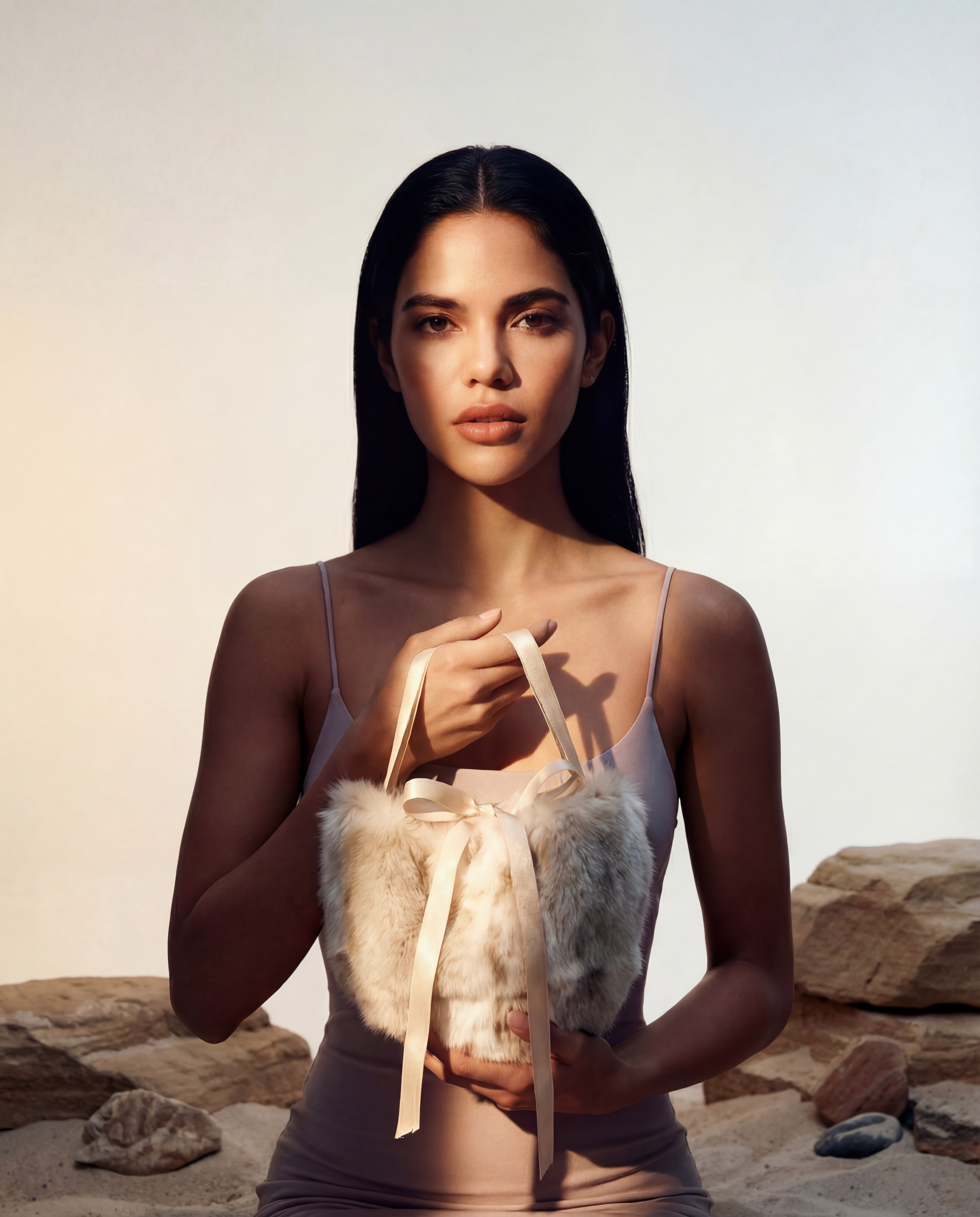 Sac en fausse fourrure vegan beige ivoire, texture douce et soyeuse, silhouette souple avec rubans satinés, style couture élégant, fabrication artisanale à Paris