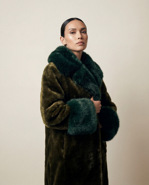 Manteau long femme en fausse fourrure vegan vert profond, poils courts brillants, col et poignets oversize contrastés, coupe droite structurée, confection artisanale parisienne Maison Quivernay. 